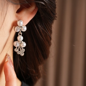 Gros plan de boucles d'oreilles de mariée avec perles et cristaux au design multicouche