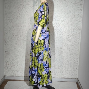 Détail de la robe longue à taille haute avec des motifs floraux violets et verts élégants