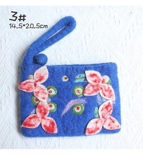 Detail view of handmade wool felt bag with flower patterns and dimensions 14.5x20.5cm