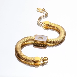 Detail of gold snake chain bracelet with white shell inlay and square cubic zirconia