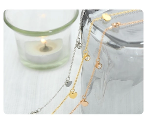 Detailed close-up of heart and zircon pendant necklaces in gold, silver, and rose gold