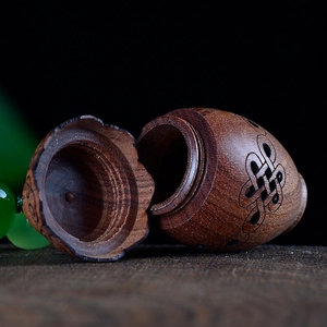 Macro shot of carved sandalwood sachet featuring intricate Chinese knot hollowed patterns