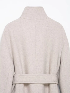 Dettaglio ravvicinato della parte posteriore di un cappotto lungo beige con cintura