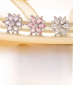 Macro detail of titanium steel zircon flower earrings in purple, pink and clear