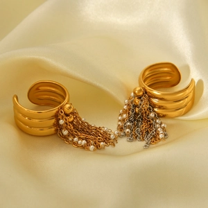Détail de boucles d'oreilles 18K dorées avec chaînes à pompons et perles blanches