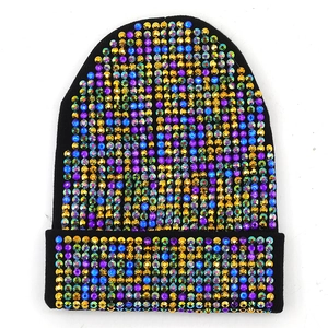 Dettaglio di strass colorati su un berretto nero in maglia con texture di alta qualità