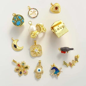 Flat lay of diverse gold charms with pearls and zircon for jewelry making
