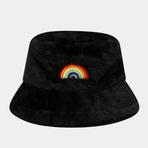 Detail of black faux fur bucket hat featuring a colorful rainbow embroidery on soft plush fabric