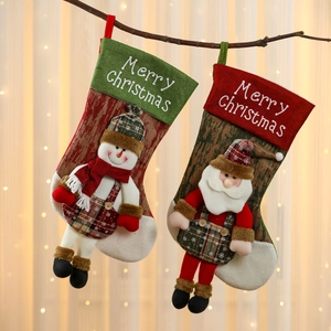 Extra large Christmas stockings with snowman and Santa patterns hanging on branches