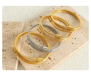 Detailed shot of gold and silver tubogas bracelets on natural stone display stands
