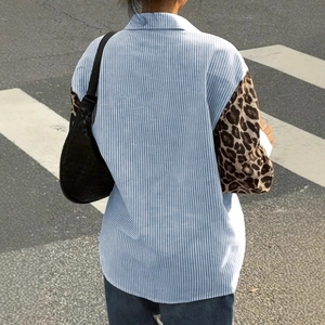 Detail of loose-fit striped shirt with leopard print patchwork sleeves and pocket design