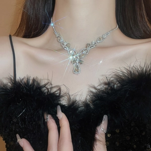 Close-up of sparkling silver rhinestone water drop floral pendant on a female model