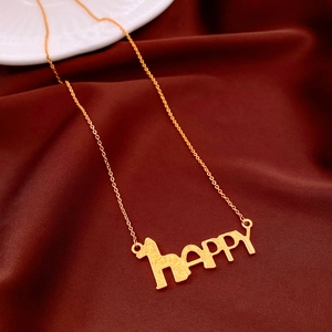 Macro shot of gold-plated HAPPY letter pendant necklace on luxurious dark silk fabric