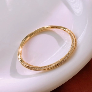 Detail of gold-plated twisted bracelet featuring sparkling pavé cubic zirconia setting