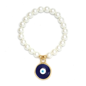 Makroaufnahme von weißen Perlen und einem blauen Evil Eye-Anhänger an einem Goldarmband
