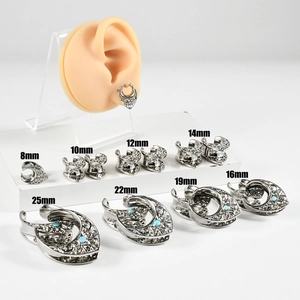 Macro view of stainless steel ear gauges with blue opal and filigree in various sizes