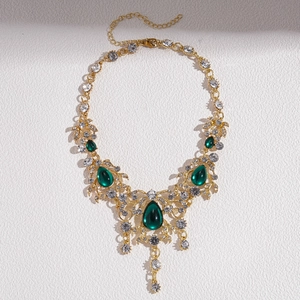 Detailansicht einer Vintage Goldkette mit smaragdgrünen Wassertropfen-Anhängern