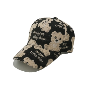 Detail of embroidered Happy Little Bear and text on black cotton baseball cap fabric