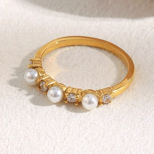 Macro detail of 18K gold plated ring with white pearls and sparkling cubic zirconia stones