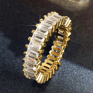 Makroaufnahme eines goldenen Eternity-Rings mit Zirkonia im Baguetteschliff und Krallen