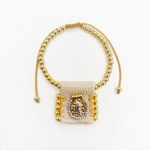 Detailed view of woven religious charm bracelet with golden beads and Guadalupe pendant