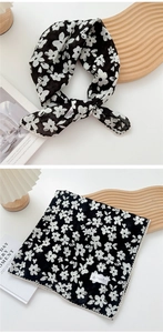 Detail of floral square scarf with black floral print and white delicate lace edges