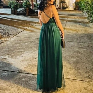 Detail of cross straps on the open back of a dark green mesh evening gown for parties