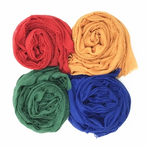 Flat lay detail of pleated wrinkle cotton scarves in red yellow green and blue colors