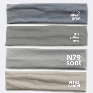 Vertical stack of four knitted sports headbands in grey, yellow, and tan colors