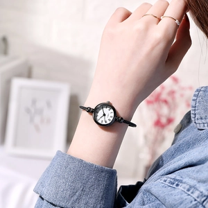 Detail of minimalist quartz bangle watch with black Roman numerals and wire band