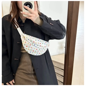 Selfie allo specchio del marsupio in tela bianca a pois colorati indossato da una modella
