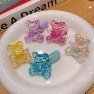 Five colorful transparent bear-shaped high-elastic hair ties on a white plate