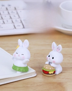 Close-up of cute resin rabbit figurines on desk with colorful matte finish details