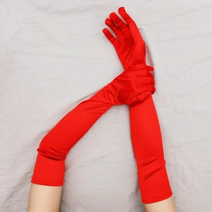 Dettaglio di guanti lunghi in raso rosso con tessuto elasticizzato e trama liscia