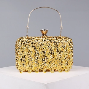 Detailed view of golden evening bag with sparkling sequins and hanging crystal beads