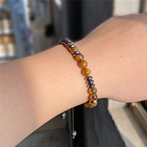 Tiger eye and hematite beaded woven bracelet on wrist for a vintage Morse code style