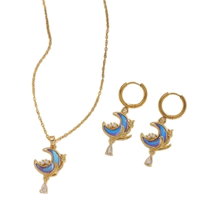 Golden moon jewelry set with iridescent stones and teardrop crystals on white background