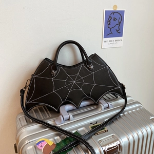 Detail of black bat-shaped PU leather handbag featuring white spiderweb stitching decoration