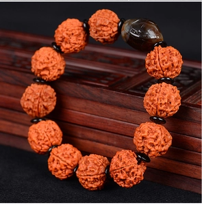 Close-up of natural Rudraksha beads with brown agate accent on carved wood box