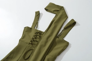 Dettaglio dell'abito verde oliva con fibbie in metallo regolabili e lacci laterali eleganti