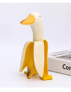Creative banana duck resin figurine with matte yellow finish standing on white surface
