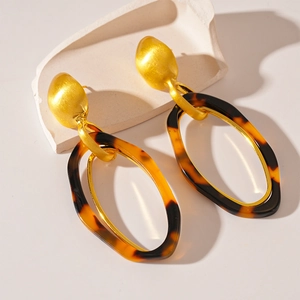 Detailed close-up of retro leopard print resin earrings with golden matte metal finish