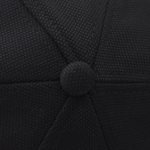 Macro detail of black honeycomb textured fabric and button on the baseball cap crown