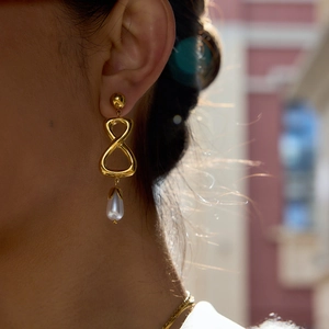 Boucles d'oreilles élégantes dorées en forme d'infini avec perle blanche en goutte