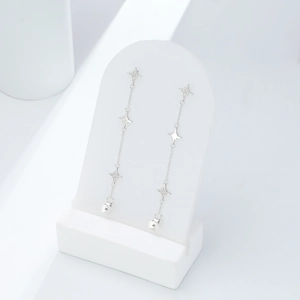 Macro shot of S925 sterling silver star fringe earrings on a white jewelry display stand