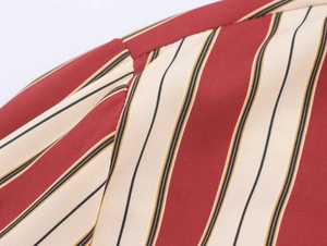 Gros plan sur la texture du tissu à rayures verticales rouges et beige et les coutures