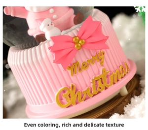 Close-up of pink Christmas music box with golden Merry Christmas text and resin bow detail