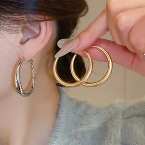 Minimalist large C-shaped hoop earrings in gold and silver finish for stylish women