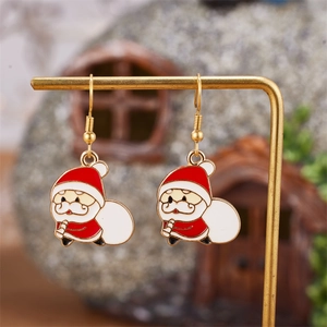 Detailed view of festive Santa Claus enamel earrings with gold metal accents