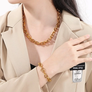 Polished gold stainless steel thick chain necklace and bracelet set on a model